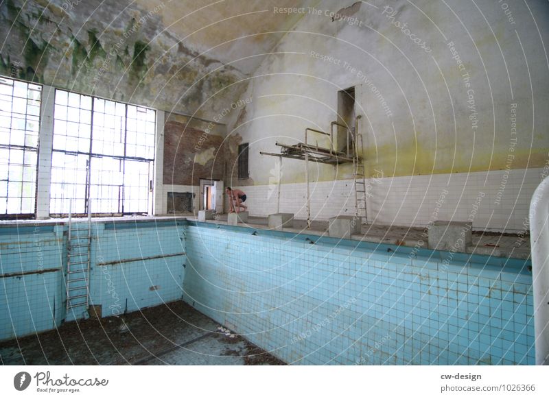 Junger Mann am Startsprung vor leerem Schwimmbecken Schwimmhalle Jugendlicher startsprung Schwimmbad Farbfoto Innenaufnahme Mensch Schwimmen & Baden Wasser blau