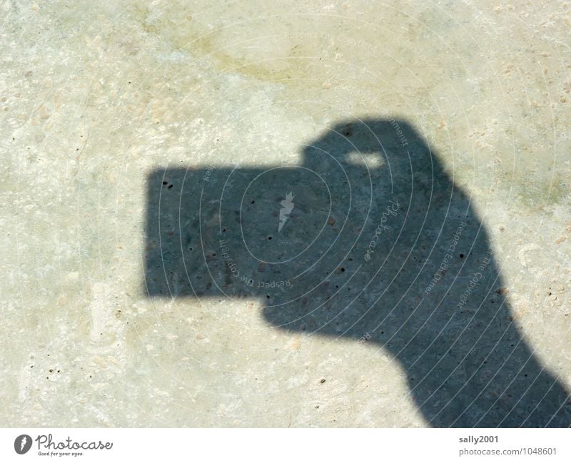 Knips... Fotokamera Hand Finger klein Fotografieren Auslöser Steinboden Schattenspiel festhalten Silhouette eckig Farbfoto Außenaufnahme Menschenleer Tag