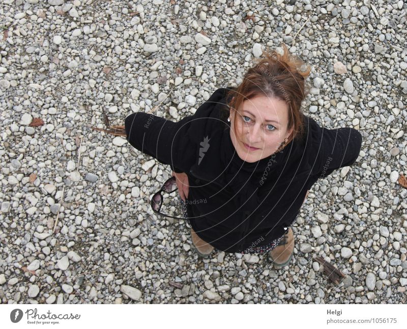 Frau mit brünetten hochgesteckten Haaren schaut freundlich nach oben in die Kamera Mensch feminin Erwachsene 1 30-45 Jahre Frühling Seeufer Jacke Wanderschuhe