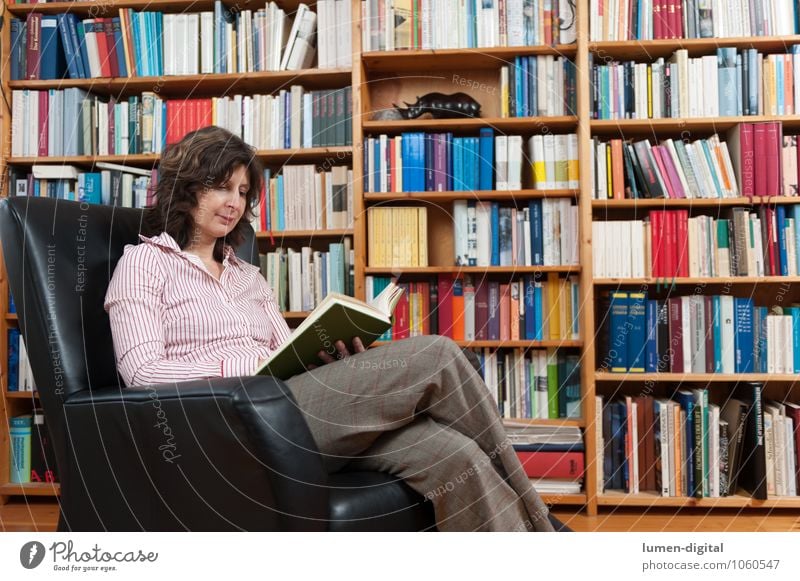 Lesende Frau im Sessel sitzend   ein lizenzfreies Stock Foto von 