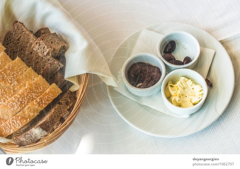Nahaufnahme des Tisches im griechischen Restaurant. Oliven und Brot Käse Frühstück Abendessen Vegetarische Ernährung Teller Gabel lecker grün schwarz weiß