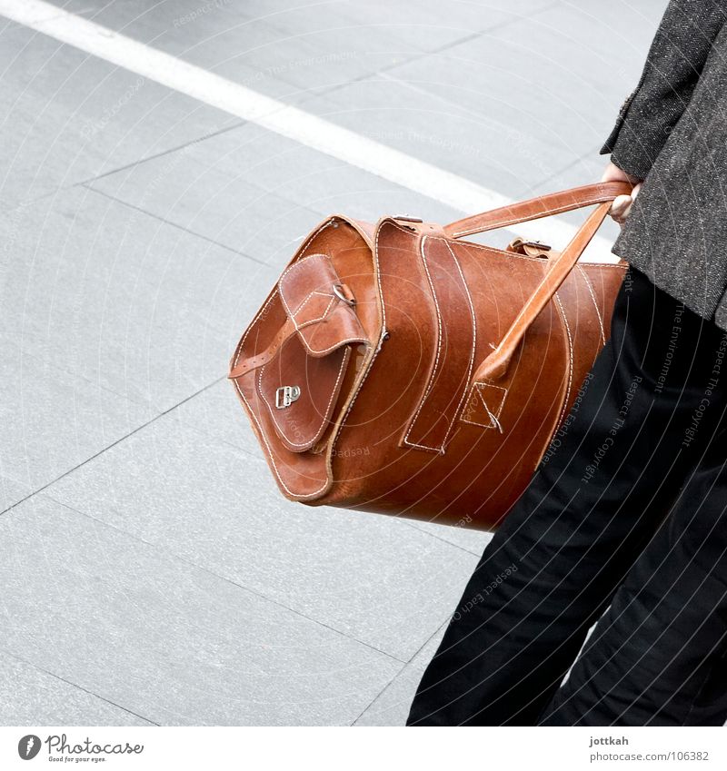 eine Person hält eine Reisetasche aus Leder in der Hand Tasche Koffer Gepäck Ferien & Urlaub & Reisen wegfahren braun Mann festhalten Quadrat Tragegriff Griff