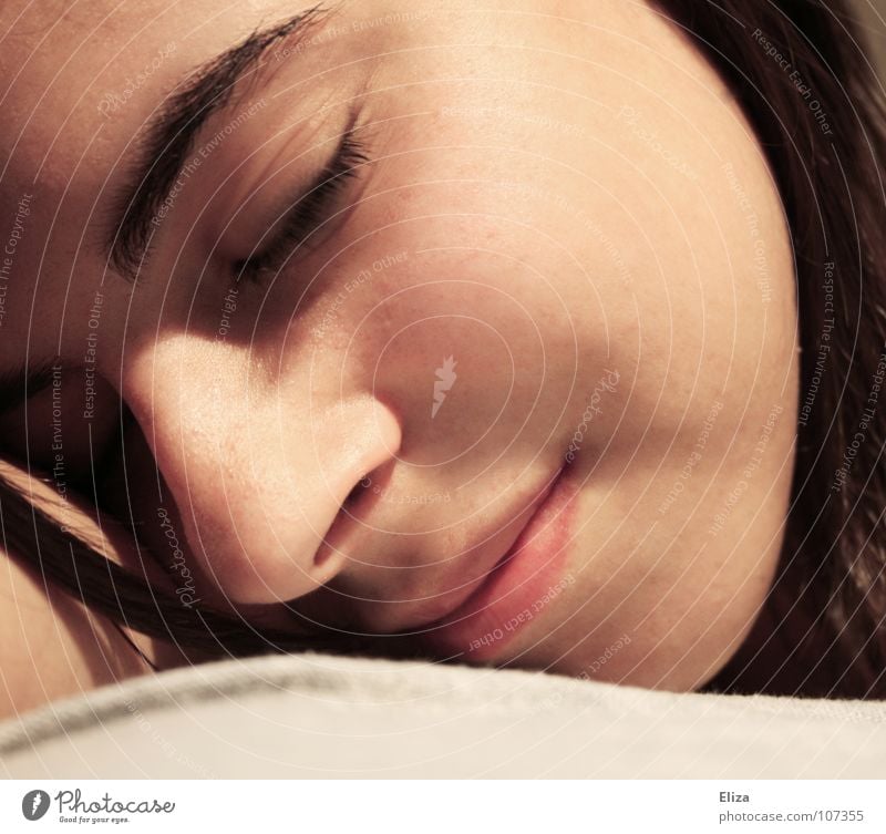 Gesicht einer entspannten jungen Frau Porträt schlafen träumen geschlossene Augen harmonisch zart weich Wellness liegen Halbschlaf Zufriedenheit Haarsträhne
