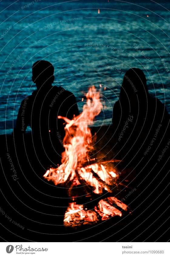 Lagerfeuer Wasser Romantik Feuerstelle Lagerfeuerstimmung Holz Erholung Partnerschaft Menschengruppe Seeufer Glut Junger Mann Frau nachdenklich Zeltlager