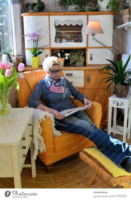 Frau zu Hause beim Lesen in einem Sessel Büffet Brunch Haare & Frisuren Leben Freizeit & Hobby lesen Sonne Häusliches Leben Wohnung Möbel Tisch Küche Feierabend