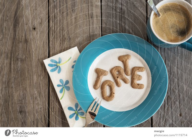 Die Buchstaben TORTE auf einem Teller mit Serviette und einer Tasse Kaffee mit Löffel auf einem rustikalen Holztisch Lebensmittel Kuchen Süßwaren Kaffeetrinken