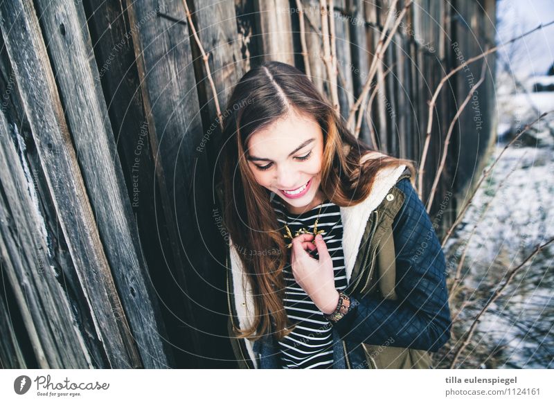 :) Winter Schnee feminin Jugendliche 1 Mensch 18-30 Jahre Erwachsene Sträucher Fassade Jacke brünett langhaarig Scheitel Holz Lächeln lachen Freundlichkeit