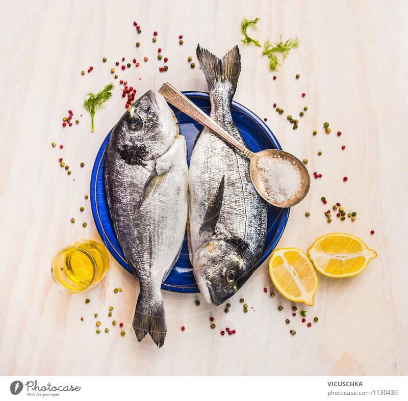 Zwei Dorado Fisch auf blauer Teller mit Öl und Zitrone Festessen Stil Design Gesunde Ernährung Tisch Küche Feinschmecker Delicious roh Zutaten Kräuter & Gewürze
