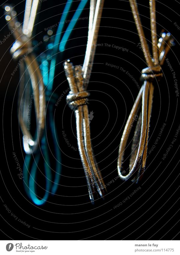 Nach dem Fest ist vor dem Fest schwarz hängen aufhängen binden Makroaufnahme Nahaufnahme blau silber Schnur Gummiband Objektfotografie Vor dunklem Hintergrund