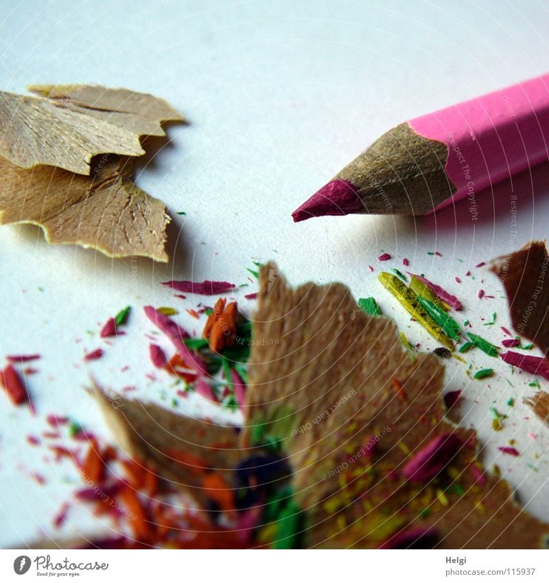 angespitzter Buntstift liegt mit dem Abfall auf dem Tisch Anspitzer Schreibstift Farbstift Holz Gesichtsausdruck mehrfarbig Müll lang dünn rosa Papier Block