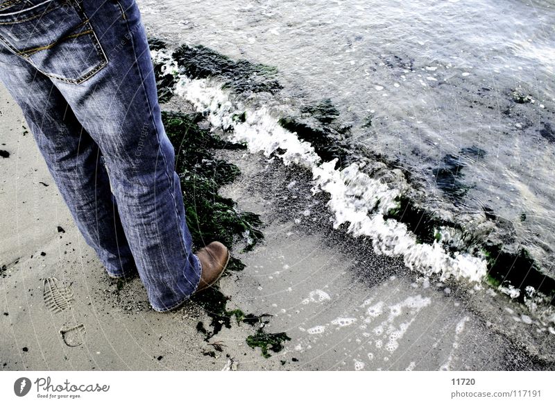 Tag am Meer Wellen Schaum Algen Ebbe Strömung Stiefel Niederlande See Sandkorn Beine Flut Jeanshose