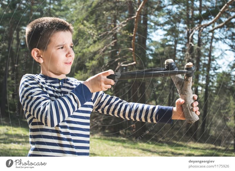 Kinderspiel mit Riemenspielzeug Freude Spielen Hooligan Mensch Junge Kindheit Hand Leder Spielzeug alt bedrohlich lustig retro weiß Gewalt Steinschleuder