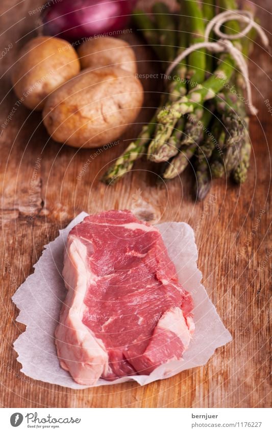 Viktualien Lebensmittel Fleisch Gemüse Ernährung Bioprodukte Billig gut roh Steak Rindersteak Spargel Kartoffeln Zwiebel rustikal Holzbrett Papier Fett