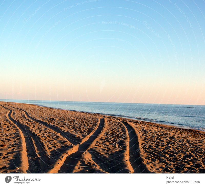 Reifenspuren im Sand  am Strand in der Abendsonne Spuren Traktorspur Küste Meer See Meerwasser Wellen Brandung Sonne Horizont Kieselsteine
