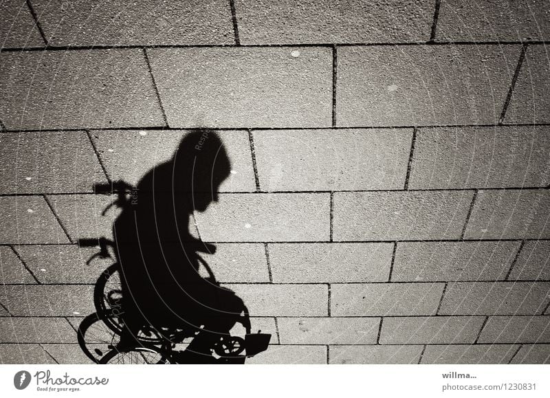 Schatten eines Menschen im Rollstuhl Mann Erwachsene 1 Mobilität Schattenspiel Schattenseite Behinderte Bodenplatten Schattendasein Einsamkeit pflegebedürftig