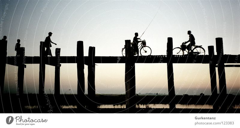 Abends in Myanmar Mandalay Teak Holz Holzbrücke Asien Abenddämmerung See Birmane Fahrrad Verkehr Brücke Mensch u-bein Pfosten Wasser Schatten Silhouette