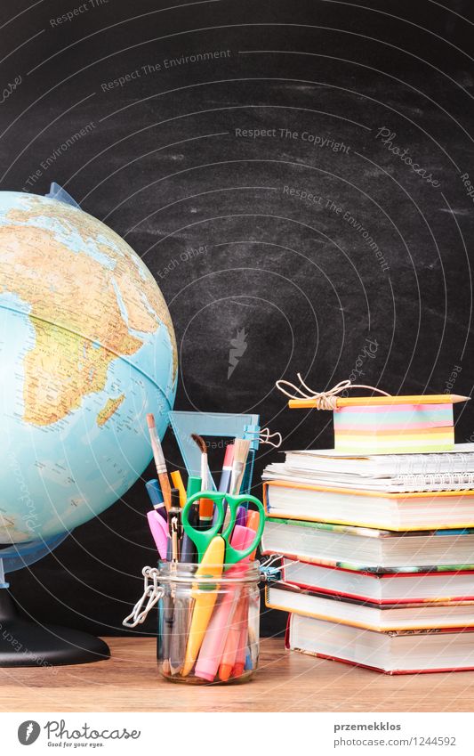 Schulzubehör mit Tafel im Hintergrund Schreibtisch Schule lernen Arbeitsplatz Werkzeug Schere Waage Buch Erde Schreibstift Globus schwarz Bildung blanko