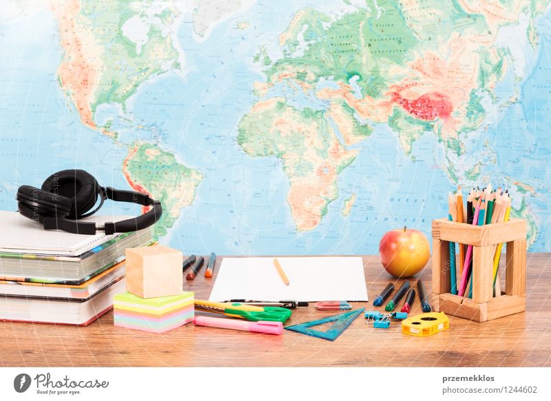 Schulzubehör auf dem Desktop mit Karte im Hintergrund Frucht Apfel Schreibtisch Schule lernen Arbeitsplatz Werkzeug Schere Buch Zettel Schreibstift