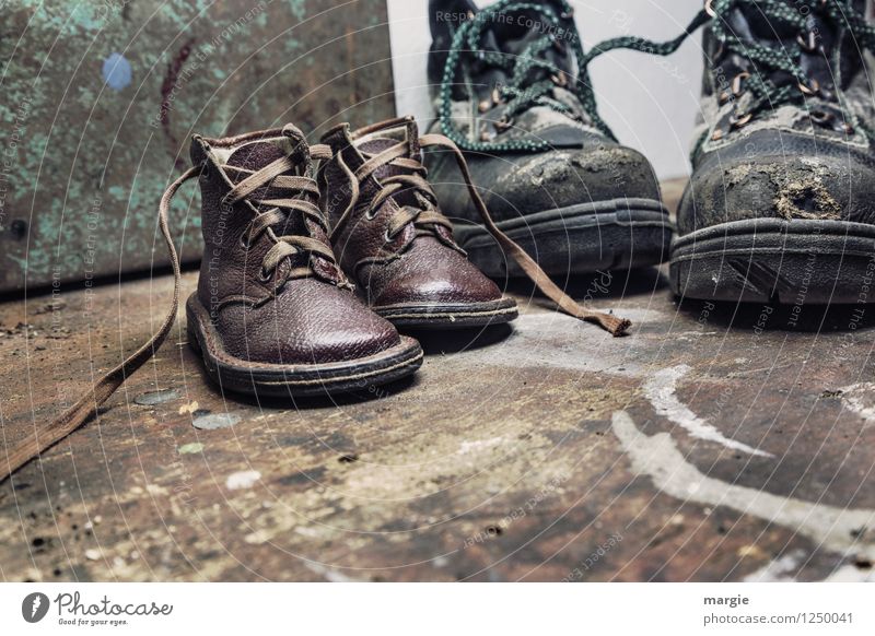 Alte  Schuhe vom Vater und dem kleinen Sohn auf einem rustikalen Holzboden Kindererziehung Arbeit & Erwerbstätigkeit Handwerker Arbeitsplatz Baustelle