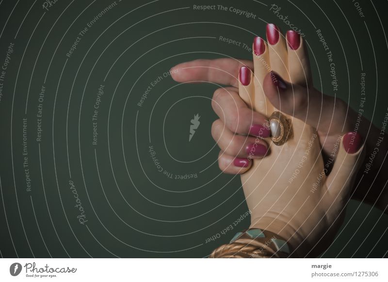 Kaltes Händchen: Eine Menschenhand und eine Puppenhand Nagellack Business feminin Hand Finger Mode Ring grün Sympathie Freundschaft Zusammensein Liebe