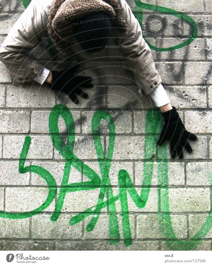 i spam you voll Kerl Mann Wand Mauer Glätte Spray Farbdose grün Aufschrift Wort E-Mail ungebeten nervig unabsichtlich hängen Mütze Handschuhe schwarz Jacke