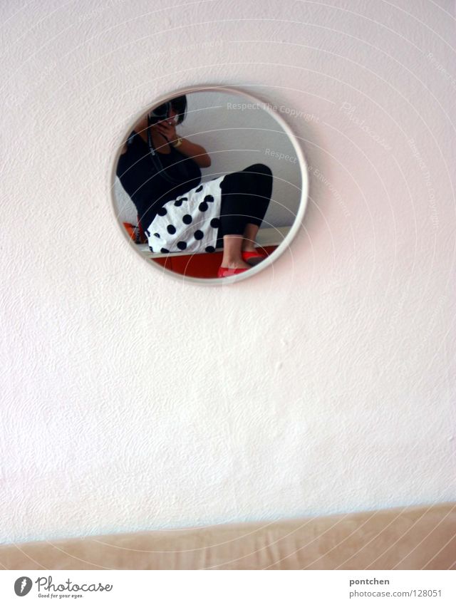 Mode Junge Frau im Rock mit Punkten fotografiert sich im Spiegel. Wohnung rund Wohnzimmer Spiegelbild Wand weiß Bekleidung Stil schwarz beige
