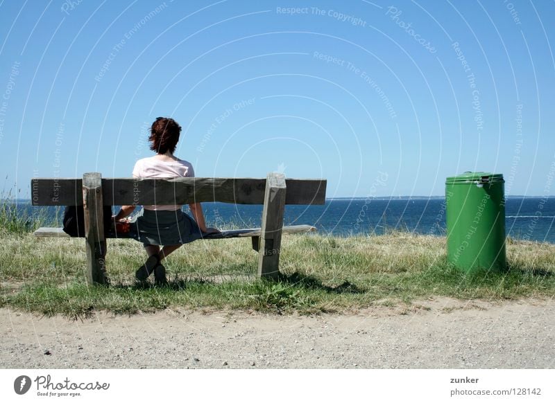 Weitblick Frau Holz Müllbehälter grün Meer Ferne Gras Einsamkeit Pause Außenaufnahme Konzentration Strand Küste Rücken Bank Wasser Himmel Schönes Wetter blau