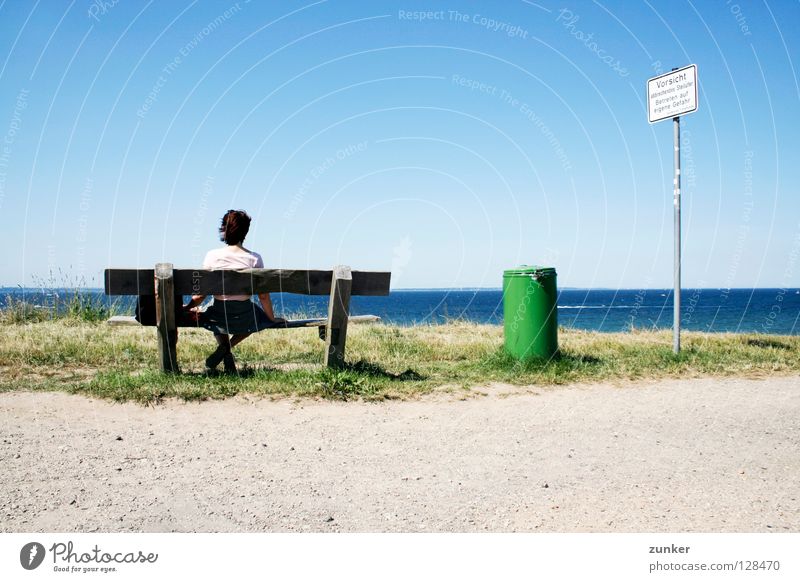 Vorsicht! Frau Holz Müllbehälter grün Meer Ferne Gras Einsamkeit Pause Außenaufnahme Strand Küste Sommer Rücken Bank Wasser Himmel Schönes Wetter blau Wind