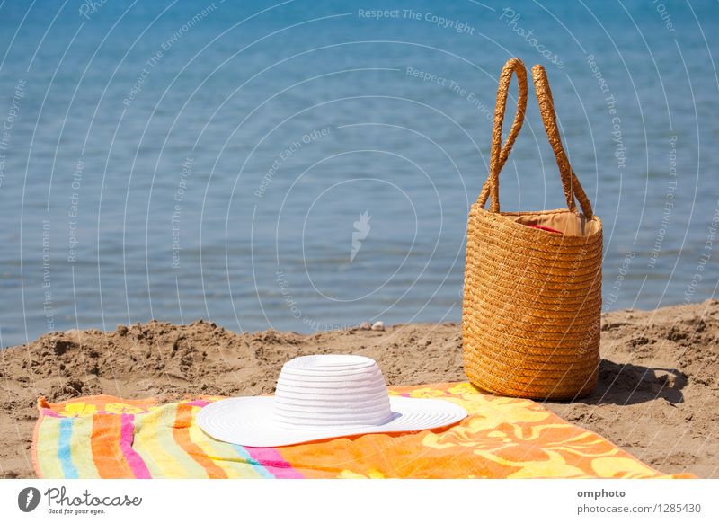 Mehrere Strandaccessoires, Tasche, Hut und farbiges Handtuch auf den Sand in der Nähe des Meerwassers gelegt Erholung Freizeit & Hobby Ferien & Urlaub & Reisen