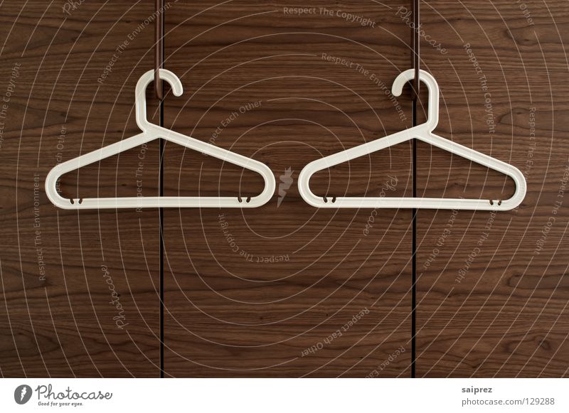 zweisam Kleiderbügel Bekleidung Schrank Holz hängen aufhängen entkleiden Innenaufnahme Haushalt Kleiderbügel weiss Plastikbügel Maserung Ordnung Kirschbaumholz