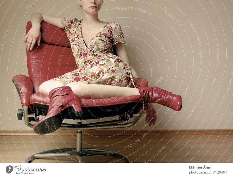 Sit-in. Körperhaltung Frau Sessel Leder Schuhe Blume Kleid Bekleidung Stiefel rot mehrfarbig Möbel lümmeln hocken Oberschenkel Unterschenkel hängenbleiben