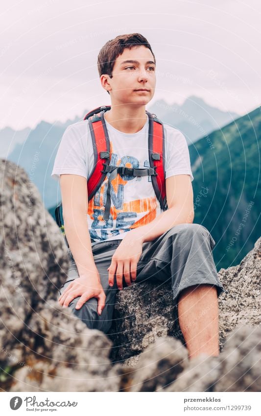 Junge, der auf dem Felsen in den Bergen sitzt Ferien & Urlaub & Reisen Abenteuer Sommer Berge u. Gebirge wandern Kind 1 Mensch 13-18 Jahre Jugendliche Natur