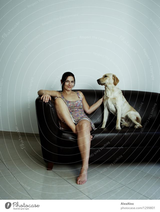 Du und dein Hund Lifestyle Freude Spielen Sofa Raum Junge Frau Jugendliche Beine Fuß 18-30 Jahre Erwachsene Sommerkleid Barfuß schwarzhaarig Labrador Lächeln