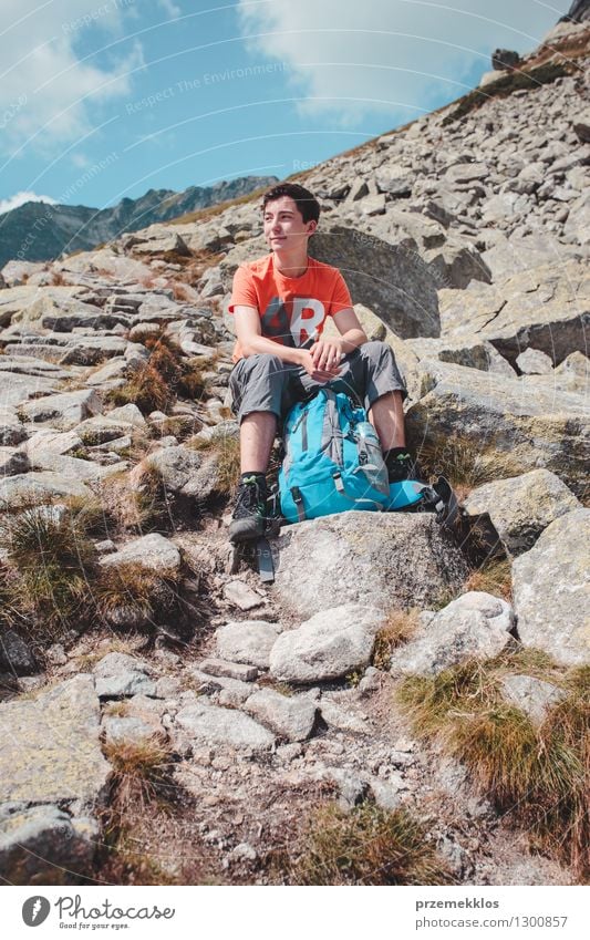 Junge, der auf einem Felsen in den Bergen stillsteht Lifestyle Ferien & Urlaub & Reisen Ausflug Abenteuer Freiheit Sommer Berge u. Gebirge wandern Junger Mann