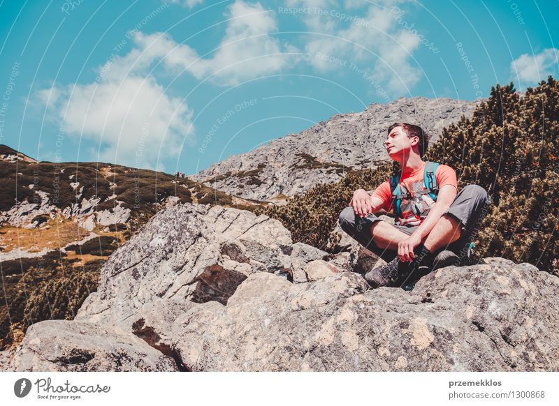 Junge, der auf einem Felsen in den Bergen stillsteht Lifestyle Ferien & Urlaub & Reisen Ausflug Abenteuer Freiheit Sommer Berge u. Gebirge wandern 1 Mensch