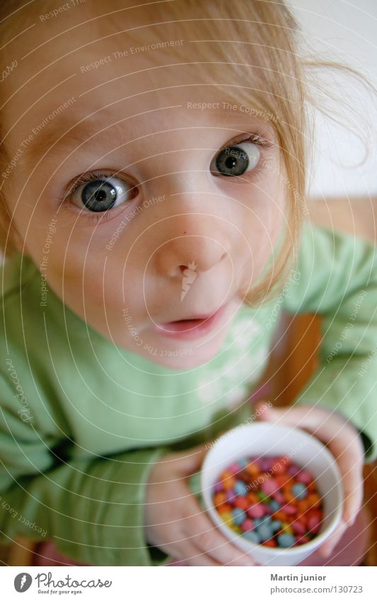 Kinderglück Mädchen Schokolinsen Ernährung süß geheimnisvoll erstaunt Überraschung Süßwaren Kleinkind Meins Glück Auge gefangen Essen