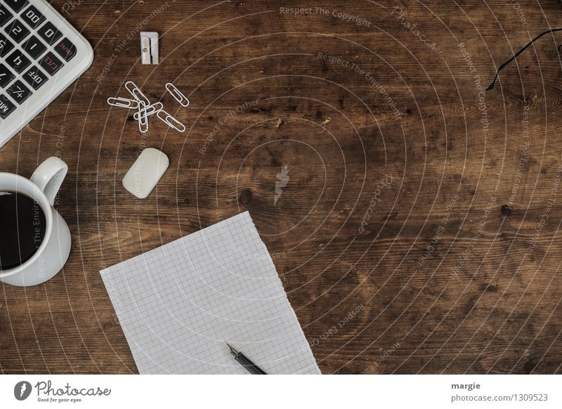 Weißer Zettel, Stift, Büroklammern, Radiergummi, Rechner und eine Tasse Kaffee auf einem alten Holz- Schreibtisch Getränk Arbeit & Erwerbstätigkeit Beruf