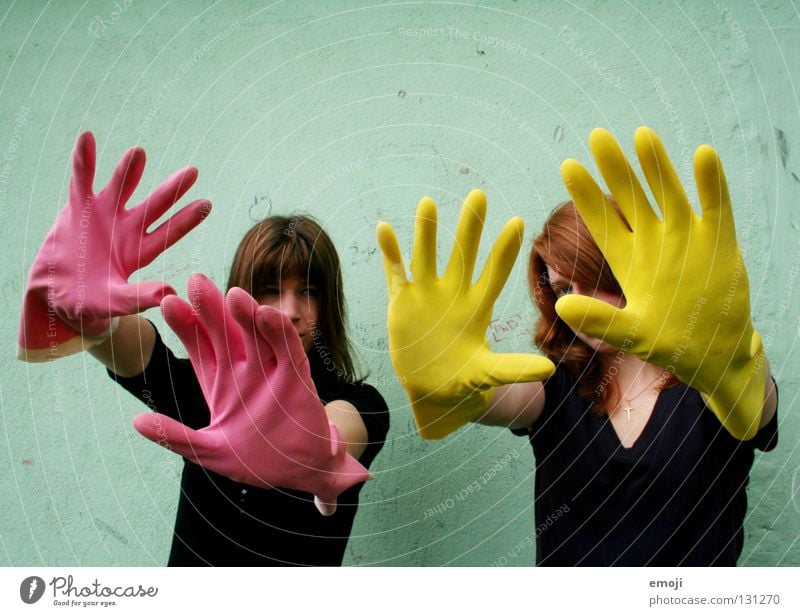 zwei Frauen mit Handschuhen Gummi rosa gelb knallig Rauschmittel türkis Wand dreckig Reinigen edel skurril seltsam Karneval obskur Finger 2 Rückansicht Luft