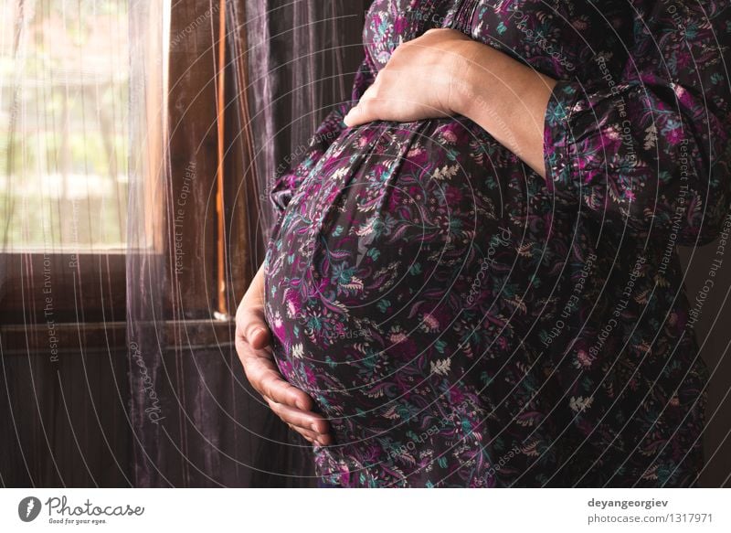Schwangere Frauen zum Fenster. Lifestyle Glück schön Leben Haus Baby Mädchen Erwachsene Eltern Mutter berühren schwanger violett Schwangerschaft Bauch heimwärts