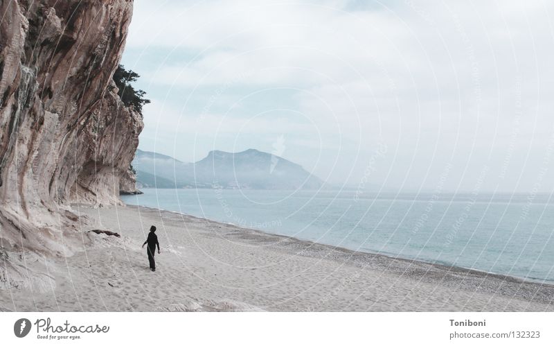 Der schwarze Mann und das Meer (und der Fels) Felswand Strand Wolken Einsamkeit taumeln Sardinien Italien Kalk klein verwundbar sensibel schlechtes Wetter Angst