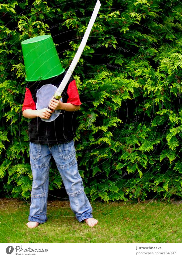 Don Quichote Junge Kind Eimer Kübel Schwert Spielen grün Helm Sportveranstaltung kämpfen verkleiden Freude Kommunizieren Ritter Garten Schutz Holzschwert