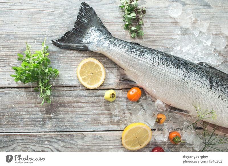 Rohe Lachsfische in Eis und Gemüse Meeresfrüchte Abendessen Tisch Koch Papier frisch lecker rot weiß Fisch Lebensmittel roh Zitrone Backpapier Messer hölzern