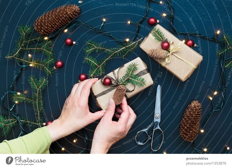 Frau, die Weihnachtsgeschenke einwickelt Schere Erwachsene Hand Papier Kasten Schnur Kultur Tradition Gast Dezember Geschenk heimwärts horizontal Kiefer