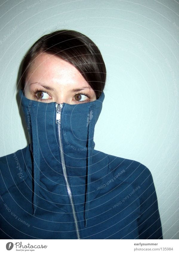 skeptisch zur Seite schauende weibliche Person mit Pullover vor Gesicht Corona-Virus Maske Maskenpflicht coronavirus Skepsis Vorsicht Schüchternheit drehen