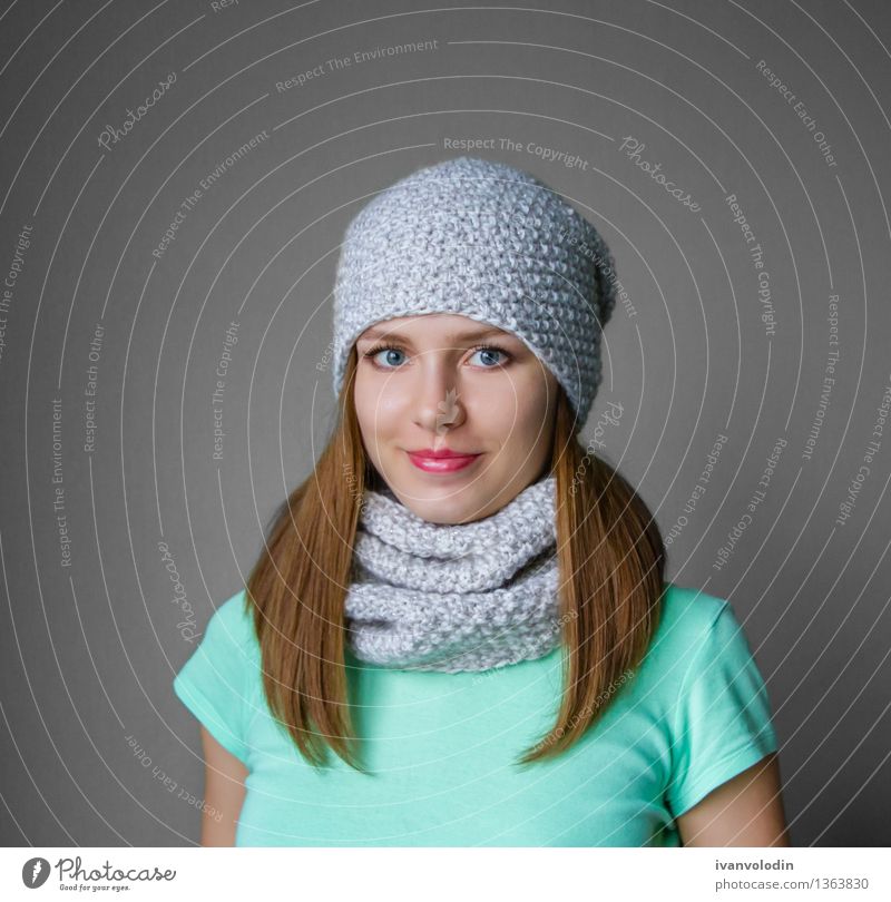 Lächelndes junges Mädchen in der Winterkappe und -schal Freude Glück schön Haut Gesicht Kosmetik Mensch Frau Erwachsene Wärme Mode Bekleidung Pullover Schal