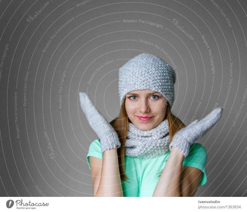 Lächelndes junges Mädchen in der Winterkappe, -schal und -handschuhen Freude Glück schön Haut Gesicht Kosmetik Mensch Frau Erwachsene Wärme Mode Bekleidung