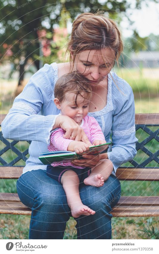 Mutter, die ein Buch ihre kleine Tochter liest Lifestyle Freude Glück schön Leben Spielen lesen Garten Kind Baby Kleinkind Mädchen Frau Erwachsene Eltern