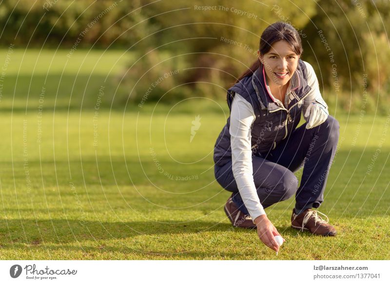 Lächelnder attraktiver junger weiblicher Golfspieler, der sich unten verbiegt Gesicht Erholung Freizeit & Hobby Spielen Sport Frau Erwachsene Natur brünett grün