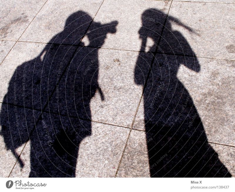 Paparazzi Farbfoto Schwarzweißfoto Außenaufnahme Schatten Silhouette Mensch Frau Erwachsene Mann Beine Verkehrswege Straße grau schwarz Asphalt steinig