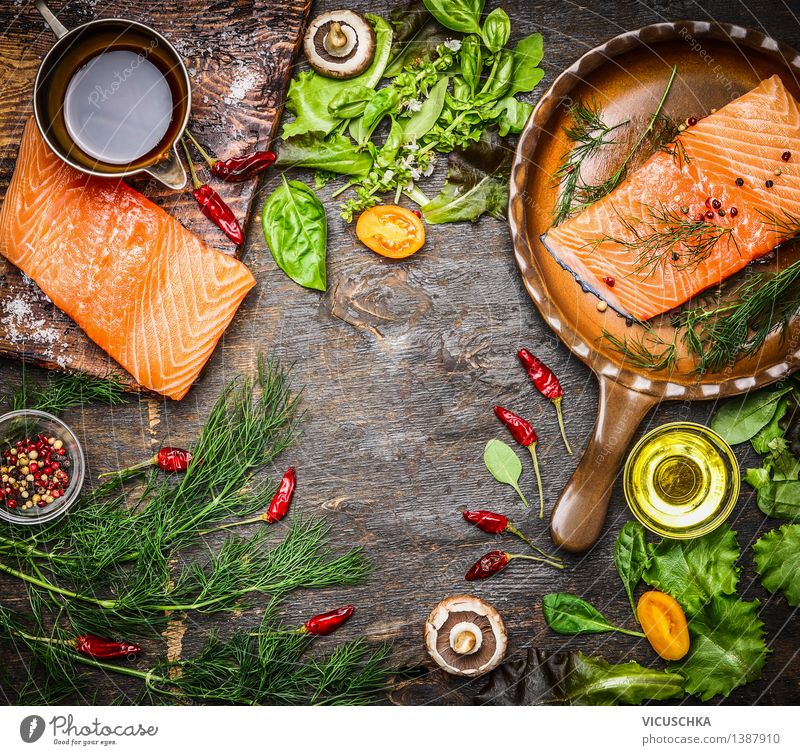 Lachsfilet auf rustikalem Küchentisch mit frischen Zutaten Lebensmittel Fisch Gemüse Salat Salatbeilage Kräuter & Gewürze Öl Ernährung Mittagessen Abendessen